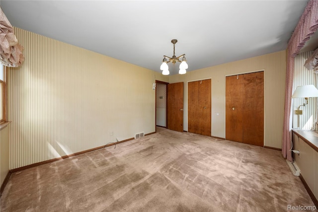 26165 Hidden Valley Dr, Farmington Hills, MI 48331 - unfurnished bedroom featuring a chandelier, multiple closets, and carpet