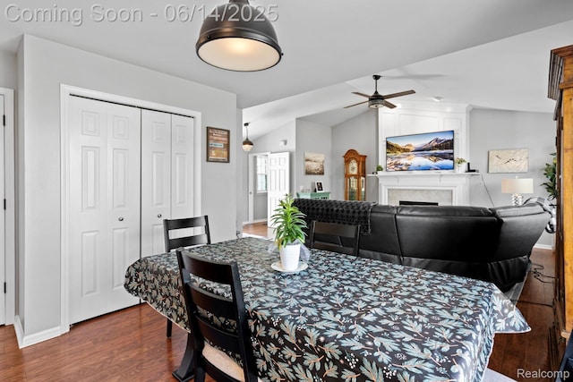 5031 Meadow Crest Cir, Holly, MI 48442 - dining room featuring wood finished floors, a ceiling fan, lofted ceiling, and a tiled fireplace