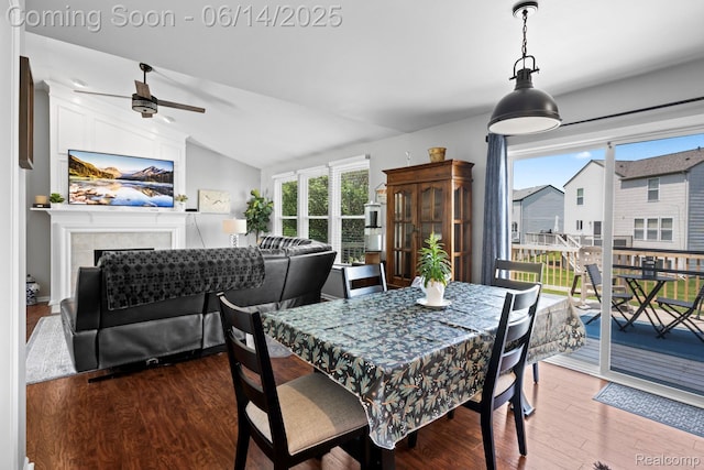 5031 Meadow Crest Cir, Holly, MI 48442 - dining room featuring healthy amount of natural light, wood finished floors, a ceiling fan, lofted ceiling, and a tiled fireplace