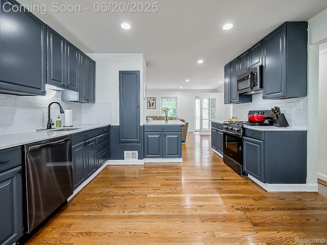 1036 Ferris Ave, Berkley, MI 48067 - kitchen with stainless steel appliances, light wood-style floors, backsplash, light countertops, and recessed lighting