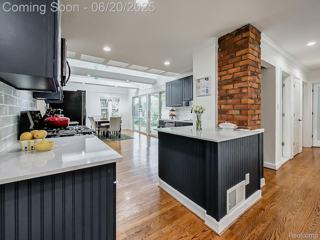 1036 Ferris Ave, Berkley, MI 48067 - kitchen featuring decorative backsplash, light wood-style floors, light countertops, recessed lighting, and freestanding refrigerator