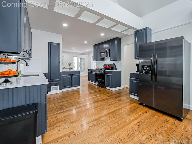 1036 Ferris Ave, Berkley, MI 48067 - kitchen with stainless steel appliances, decorative backsplash, light wood-type flooring, light countertops, and recessed lighting