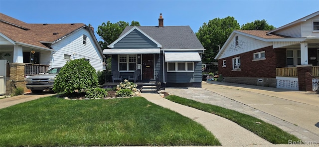 1154 Lincoln Ave, Rockwood, MI 48146 - bungalow-style house with a chimney, a porch, and a front yard