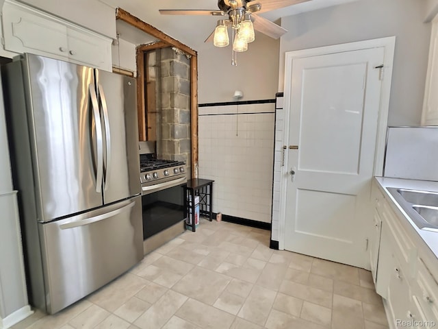 1154 Lincoln Ave, Rockwood, MI 48146 - kitchen featuring appliances with stainless steel finishes, ceiling fan, white cabinetry, light tile patterned flooring, and tile walls