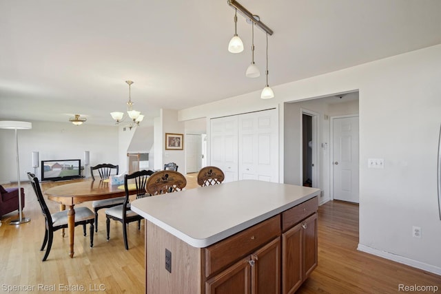 61 Old Carriage Ln, Lapeer, MI 48446 - kitchen featuring open floor plan, light wood finished floors, decorative light fixtures, and a chandelier