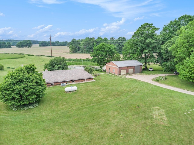 520 Groat Rd, Dowling, MI 49050 - view of green lawn featuring an outdoor structure, a detached garage, dirt driveway, and a view of rural / pastoral area
