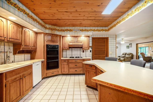 520 Groat Rd, Dowling, MI 49050 - kitchen featuring white dishwasher, under cabinet range hood, wooden ceiling, light countertops, and a tray ceiling