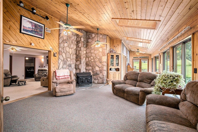 520 Groat Rd, Dowling, MI 49050 - living room featuring wood ceiling, a ceiling fan, a wood stove, vaulted ceiling, and carpet floors