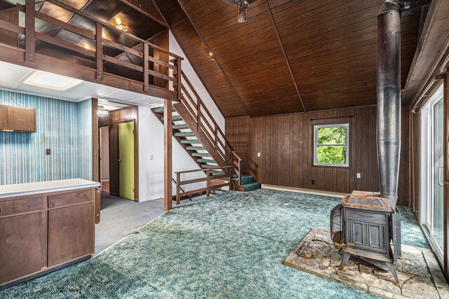 300 Basswood Ter, Brooklyn, MI 49230 - unfurnished living room with a wood stove, carpet floors, wood ceiling, stairway, and lofted ceiling