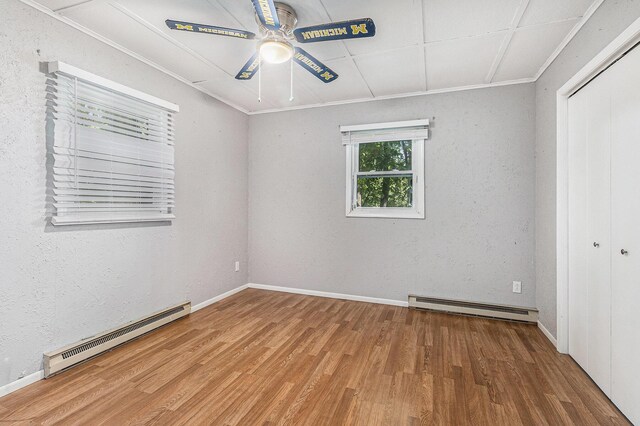 300 Basswood Ter, Brooklyn, MI 49230 - spare room featuring a baseboard radiator, a ceiling fan, wood finished floors, and ornamental molding