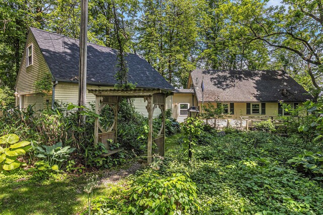 300 Basswood Ter, Brooklyn, MI 49230 - rear view of property with an attached garage and a shingled roof