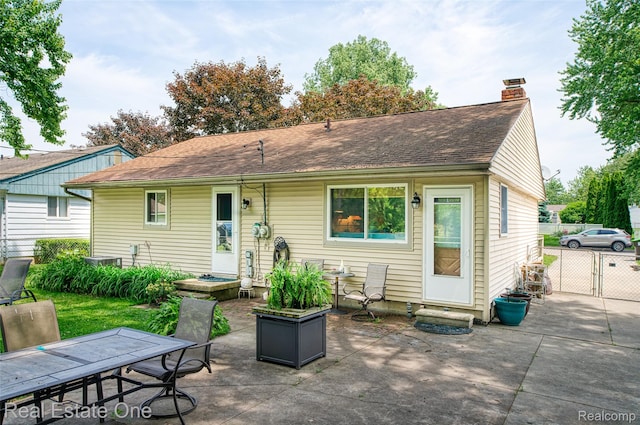 5320 Leland St, Brighton, MI 48116 - back of house with a patio area, a chimney, a shingled roof, and outdoor dining space