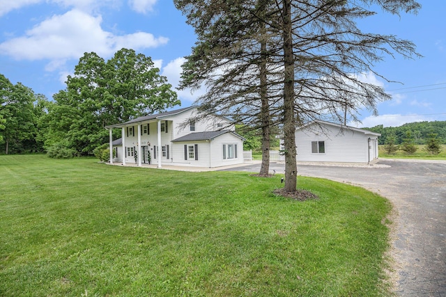 6170 Gregory Rd, Dexter, MI 48130 - neoclassical home with asphalt driveway, a front lawn, and covered porch