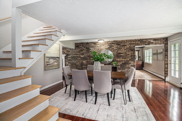 6170 Gregory Rd, Dexter, MI 48130 - dining room featuring brick wall, a baseboard heating unit, stairway, a textured ceiling, and wood finished floors