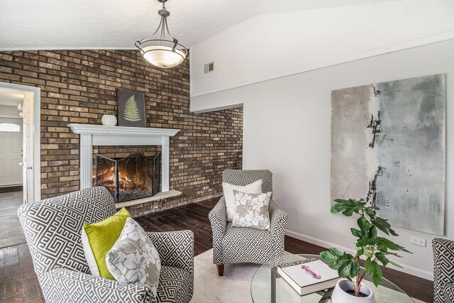 6170 Gregory Rd, Dexter, MI 48130 - living area with vaulted ceiling, wood finished floors, a brick fireplace, and brick wall