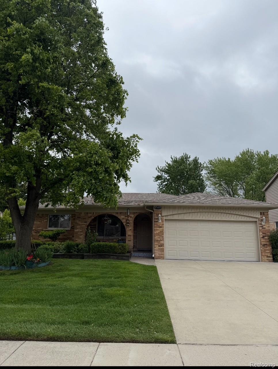 47851 Goldridge Ln, Macomb, MI 48044 - view of front of property with a garage, concrete driveway, brick siding, and a front lawn