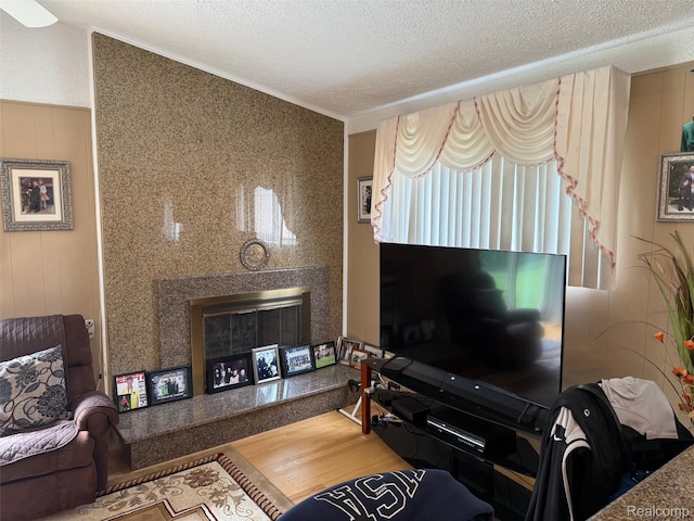 47851 Goldridge Ln, Macomb, MI 48044 - living room featuring a glass covered fireplace, a textured ceiling, wood finished floors, and ornamental molding