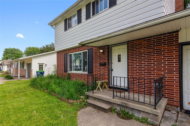 927 Piper Dr, Saginaw, MI 48604 - doorway to property featuring brick siding and a yard