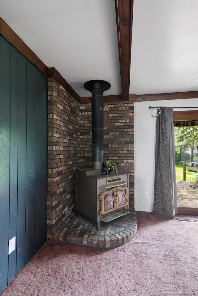 927 Piper Dr, Saginaw, MI 48604 - detailed view of a wood stove, carpet, wood walls, and beamed ceiling