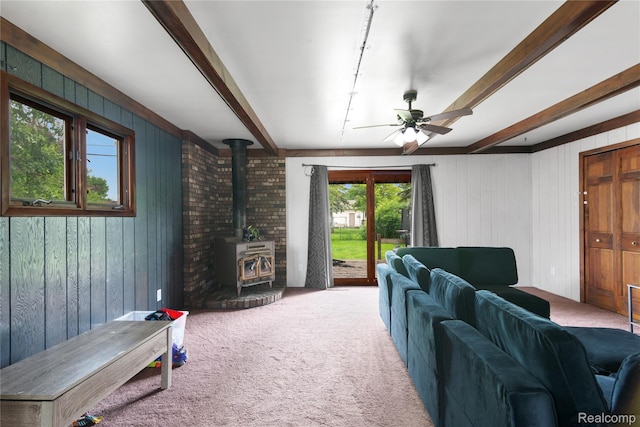 927 Piper Dr, Saginaw, MI 48604 - living area with a wood stove, beam ceiling, carpet floors, wood walls, and ceiling fan