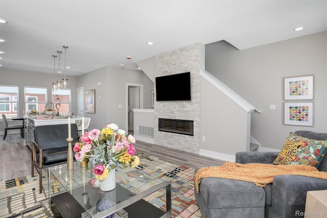 4837 Lismore Ln, Troy, MI 48085 - living room featuring a stone fireplace, light wood-type flooring, and recessed lighting