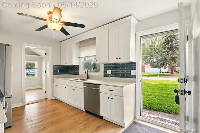 2121 Chesley Dr, Sterling Heights, MI 48310 - kitchen featuring appliances with stainless steel finishes, light countertops, backsplash, white cabinets, and light wood-style floors