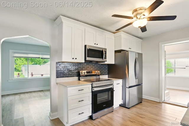 2121 Chesley Dr, Sterling Heights, MI 48310 - kitchen featuring appliances with stainless steel finishes, light countertops, light wood finished floors, white cabinets, and ceiling fan