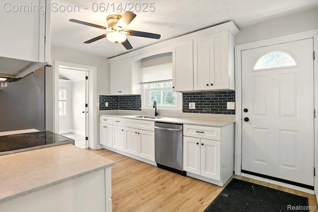 2121 Chesley Dr, Sterling Heights, MI 48310 - kitchen featuring stainless steel dishwasher, light wood-style floors, backsplash, white cabinetry, and light countertops