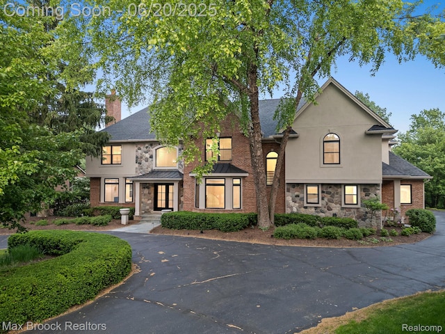 4331 Spruce Hill Ln, Birmingham, MI 48301 - view of front of home featuring stone siding, a chimney, stucco siding, and roof with shingles