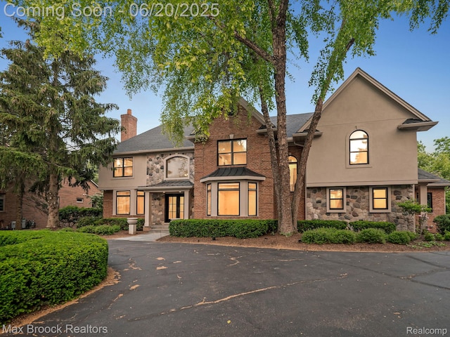 4331 Spruce Hill Ln, Birmingham, MI 48301 - view of front of house with stone siding, a chimney, and stucco siding