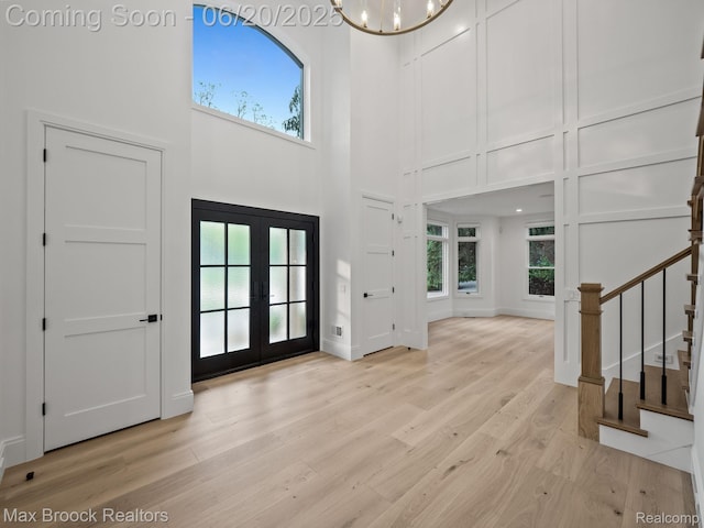 4331 Spruce Hill Ln, Birmingham, MI 48301 - foyer with a high ceiling, french doors, light wood-style floors, stairs, and a chandelier