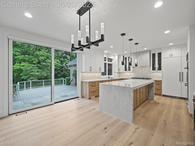 4331 Spruce Hill Ln, Birmingham, MI 48301 - kitchen with light wood finished floors, a center island, backsplash, recessed lighting, and modern cabinets