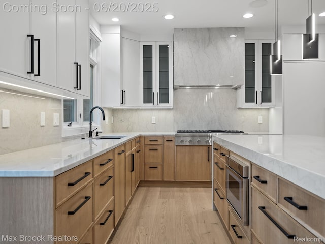 4331 Spruce Hill Ln, Birmingham, MI 48301 - kitchen featuring stainless steel gas stovetop, light stone countertops, light wood finished floors, custom exhaust hood, and glass insert cabinets