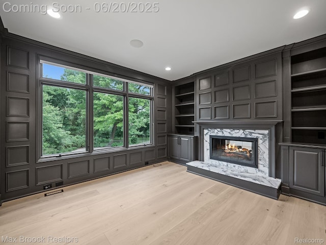 4331 Spruce Hill Ln, Birmingham, MI 48301 - unfurnished living room featuring a high end fireplace, built in shelves, healthy amount of natural light, light wood-type flooring, and recessed lighting