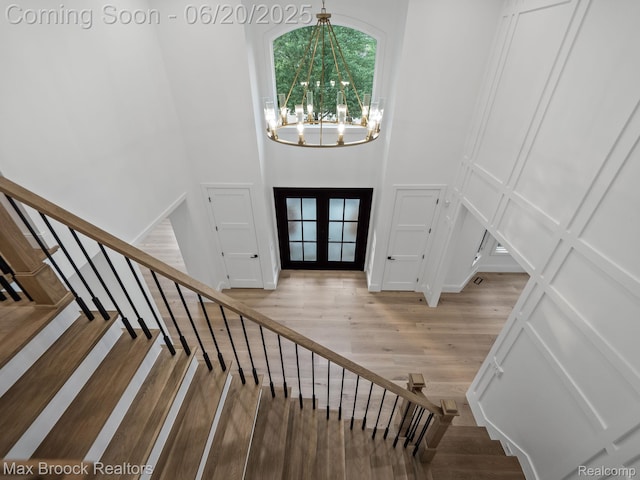 4331 Spruce Hill Ln, Birmingham, MI 48301 - staircase with a towering ceiling, a chandelier, wood finished floors, and french doors