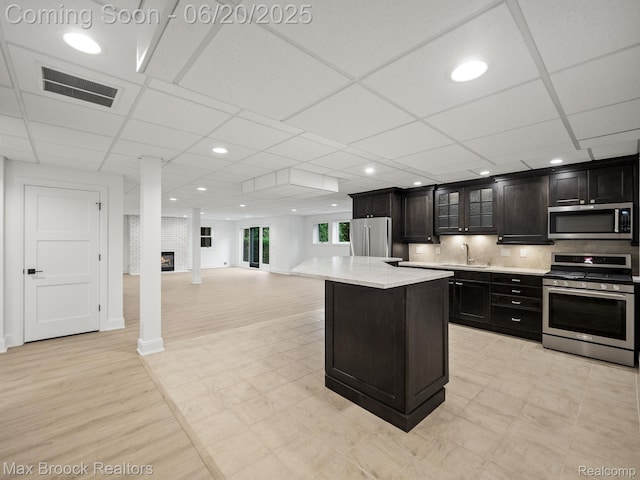 4331 Spruce Hill Ln, Birmingham, MI 48301 - kitchen with appliances with stainless steel finishes, light countertops, recessed lighting, a kitchen island, and glass insert cabinets