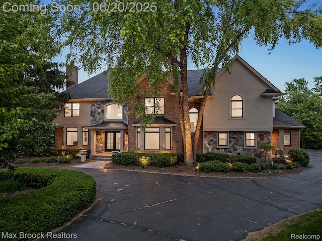 4331 Spruce Hill Ln, Birmingham, MI 48301 - view of front of house featuring stone siding, a chimney, stucco siding, and a shingled roof