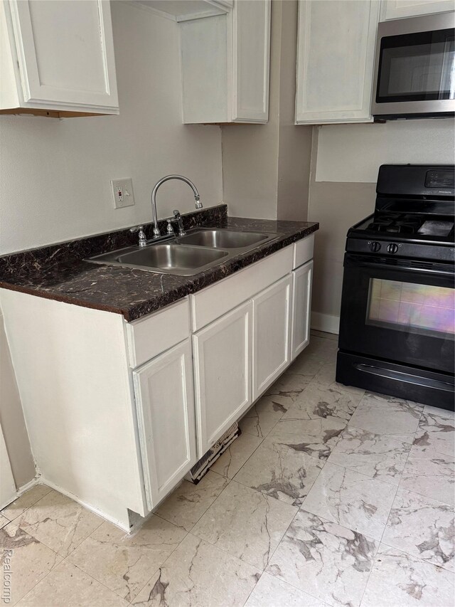 7821 Mead St, Dearborn, MI 48126 - kitchen with stainless steel microwave, gas stove, light marble finish flooring, white cabinets, and dark stone countertops