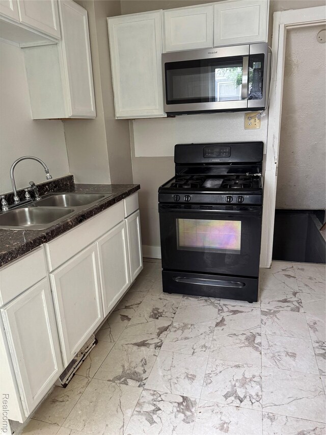 7821 Mead St, Dearborn, MI 48126 - kitchen featuring stainless steel microwave, gas stove, light marble finish flooring, and white cabinets