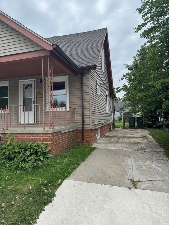 7821 Mead St, Dearborn, MI 48126 - view of property exterior featuring roof with shingles, a porch, and driveway