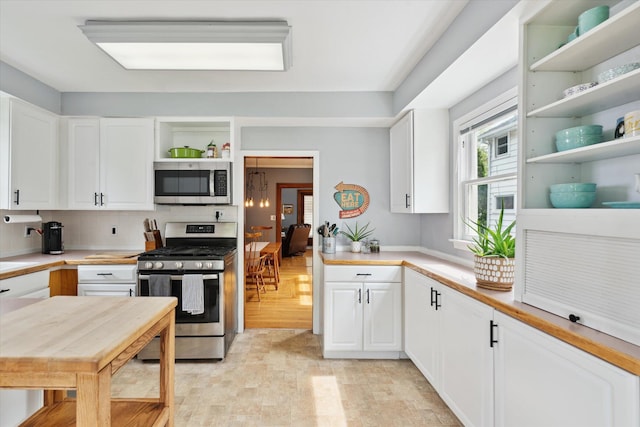 238 E E Main St, Milan, MI 48160 - kitchen featuring stainless steel appliances, open shelves, white cabinetry, and light countertops