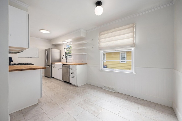 1102 Spencer St NE, Grand Rapids, MI 49505 - kitchen with wood counters, stainless steel appliances, crown molding, white cabinets, and open shelves
