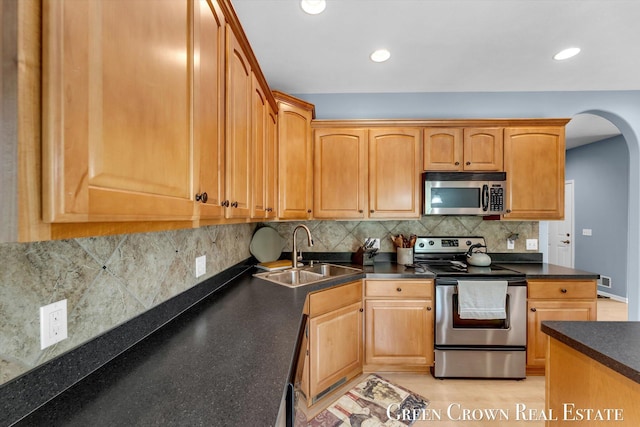 5173 Olsen Springs Ct Unit 13, Wyoming, MI 49509 - kitchen featuring appliances with stainless steel finishes, dark countertops, arched walkways, tasteful backsplash, and recessed lighting