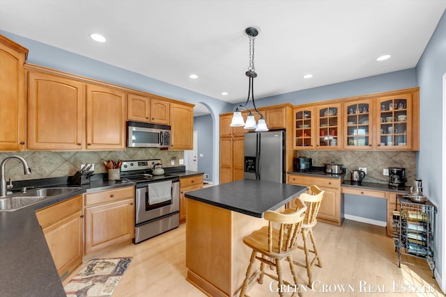 5173 Olsen Springs Ct Unit 13, Wyoming, MI 49509 - kitchen featuring appliances with stainless steel finishes, arched walkways, tasteful backsplash, dark countertops, and recessed lighting