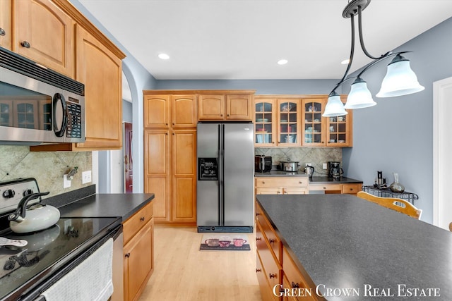 5173 Olsen Springs Ct Unit 13, Wyoming, MI 49509 - kitchen with appliances with stainless steel finishes, dark countertops, glass insert cabinets, backsplash, and light wood-style flooring