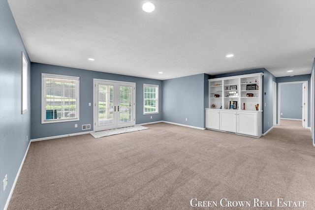 5173 Olsen Springs Ct Unit 13, Wyoming, MI 49509 - unfurnished living room with light colored carpet, healthy amount of natural light, recessed lighting, and french doors