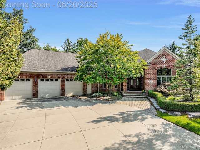 5007 Rockaway Ln, Clarkston, MI 48348 - view of front facade with brick siding, a garage, driveway, and a shingled roof