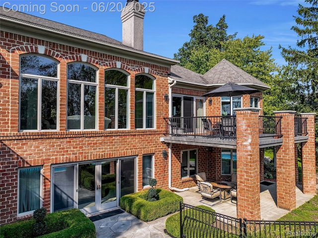 5007 Rockaway Ln, Clarkston, MI 48348 - back of property with a patio, a balcony, brick siding, and french doors