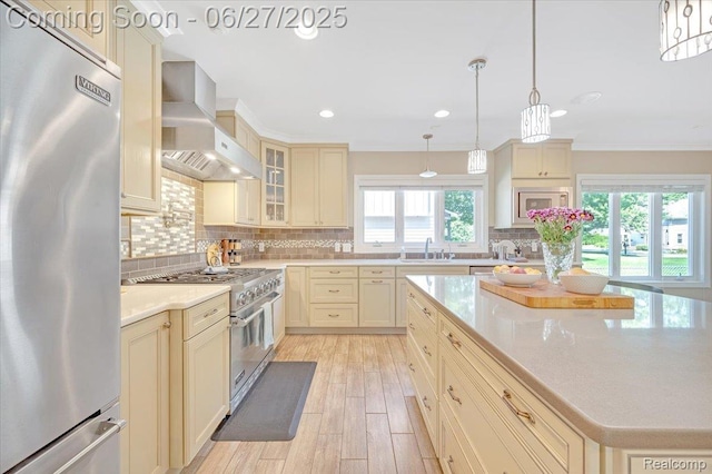 240 Red Oak Ln, Rochester Hills, MI 48307 - kitchen with appliances with stainless steel finishes, wall chimney range hood, cream cabinetry, backsplash, and recessed lighting