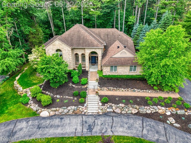 5258 Hidden Pines Dr, Brighton, MI 48116 - french country inspired facade with stairway, brick siding, stone siding, and a shingled roof